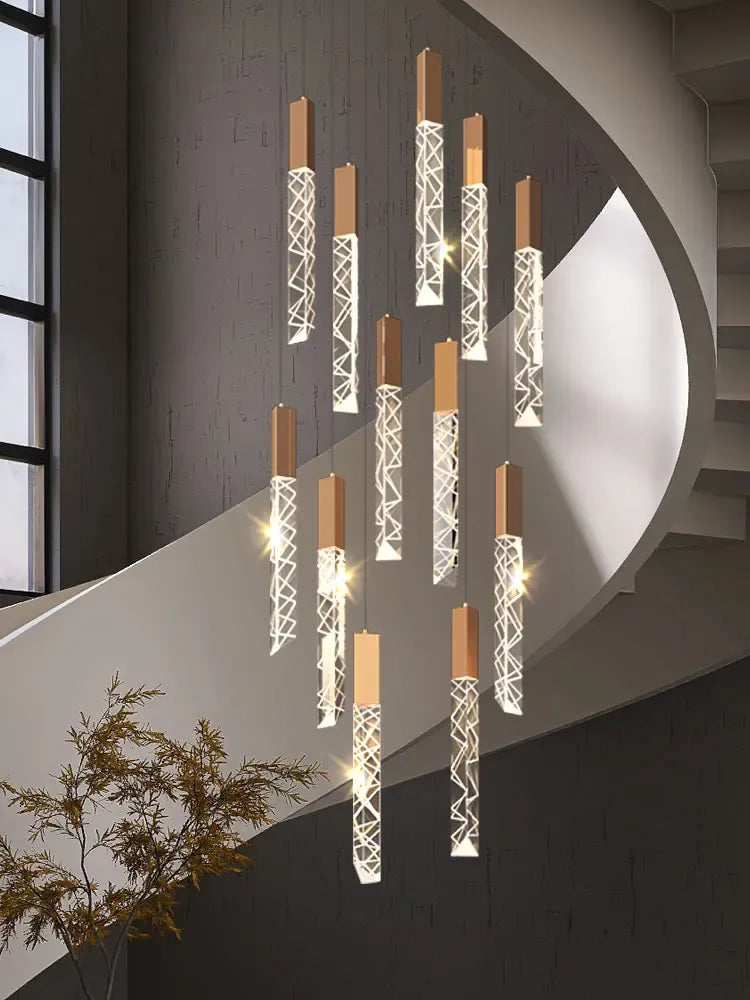 Gold K9 crystal rod chandelier installed in curved staircase with warm light