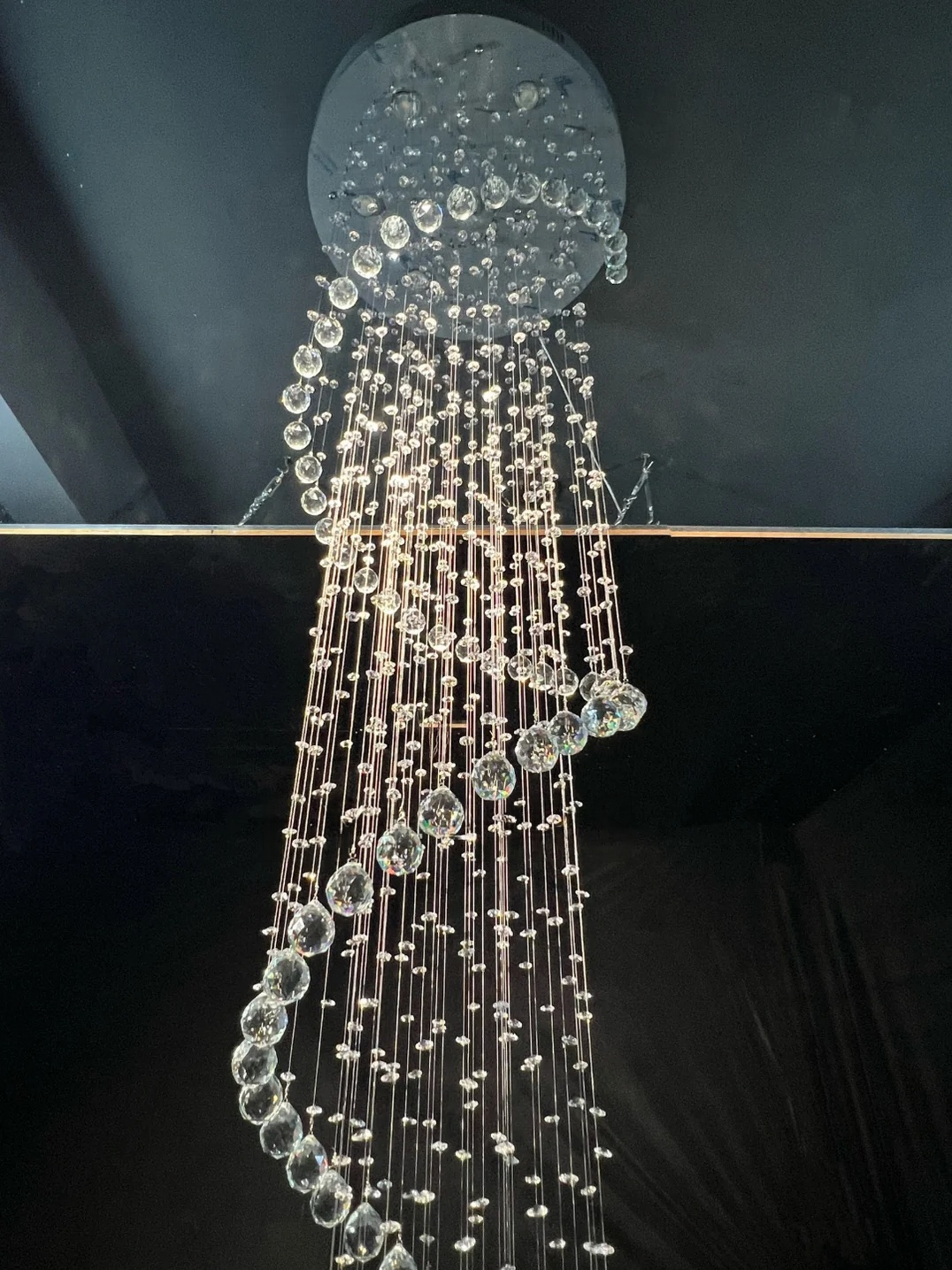 Close up of Large Foyer Lighting spiral raindrop crystal chandelier with illuminated crystal strands