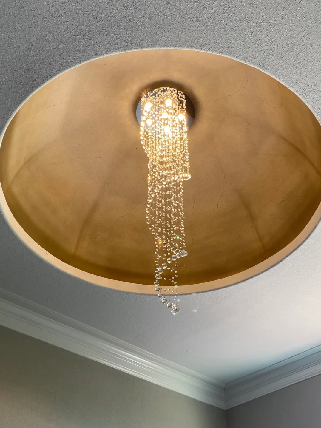 Large Foyer Lighting spiral raindrop crystal chandelier mounted in a gold ceiling recess