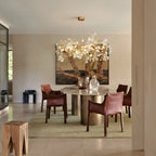 Lorna Berry Branch Shape Glass Chandelier above a round dining table with red chairs