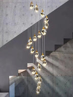 Modern Crystal Chandelier for High Ceiling Living Room arranged as a cascading cluster beside a concrete staircase
