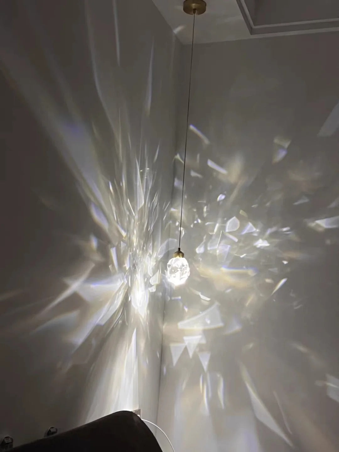 Modern Crystal Chandelier for High Ceiling Living Room casting crystal light patterns across the wall