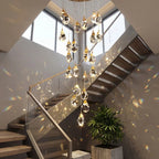 Modern Crystal Chandelier for High Ceiling Living Room creating warm reflections in a sunlit staircase and foyer
