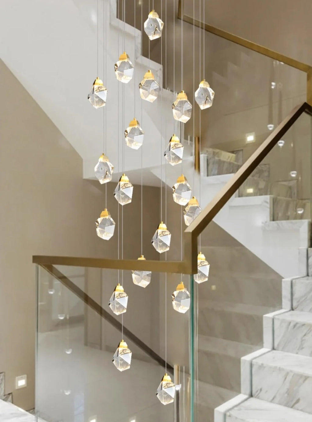 Modern Crystal Chandelier for High Ceiling Living Room installed over a white marble staircase with gold accents