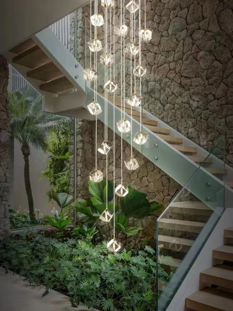 Modern Crystal Square Chandelier for Staircase installed beside stairs with a garden wall and sparkling cube crystals