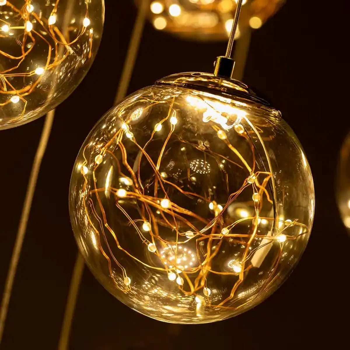 Modern Spiral Chandelier for Staircase close-up of amber glass globe with warm LED light strands
