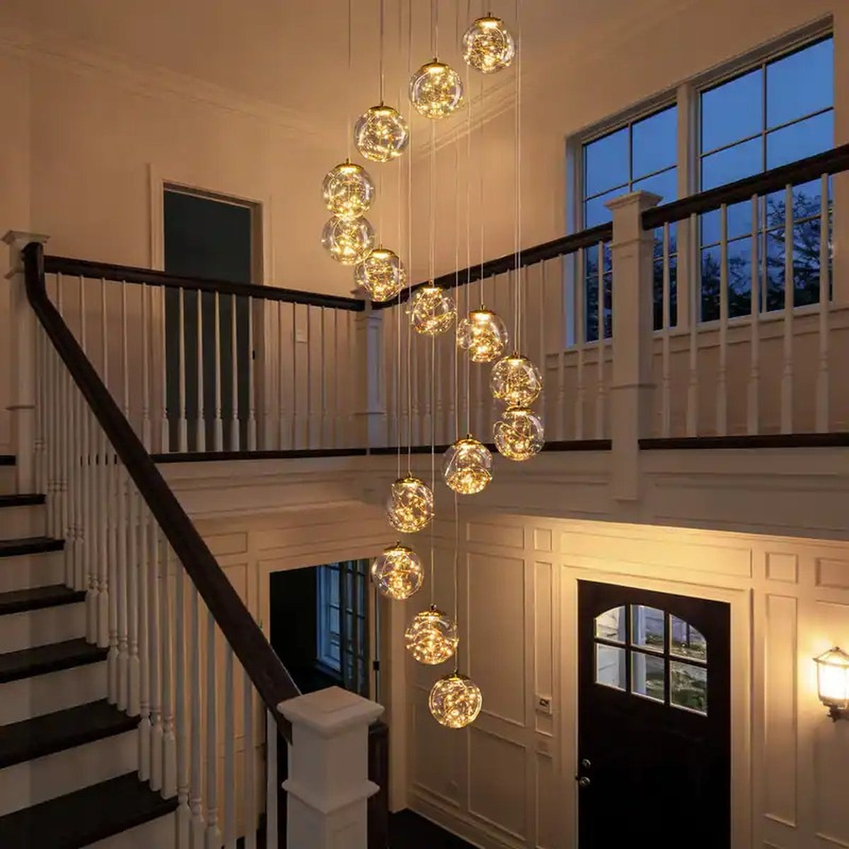 Modern Spiral Chandelier for Staircase cascading through a foyer beside an upper balcony railing
