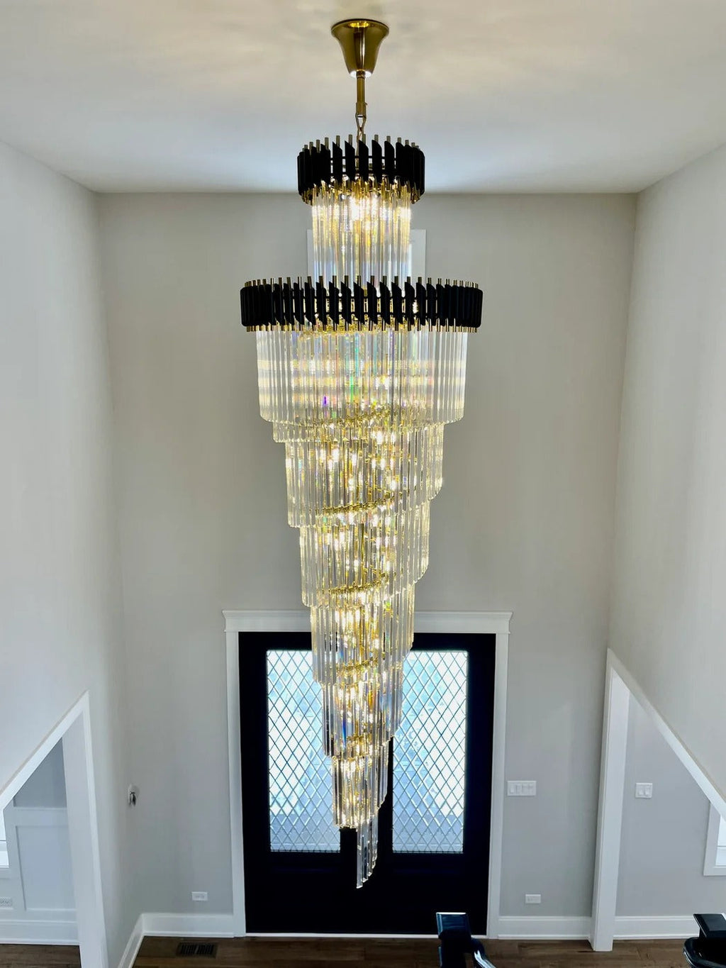 Olivia Crystal Modern Stair Chandelier installed in an entryway stairwell above double doors