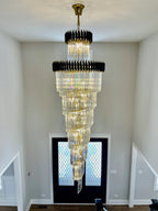 Olivia Crystal Modern Stair Chandelier installed in an entryway stairwell above double doors