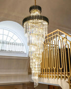 Olivia Crystal Modern Stair Chandelier installed in a foyer with decorative gold stair railing