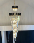 Olivia Crystal Modern Stair Chandelier installed against a high wall with layered crystal tiers