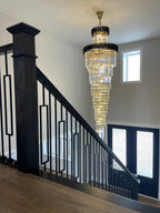 Olivia Crystal Modern Stair Chandelier installed beside a stair landing with black railings