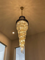 Olivia Crystal Modern Stair Chandelier warm lit tapered crystal chandelier installed near a ceiling