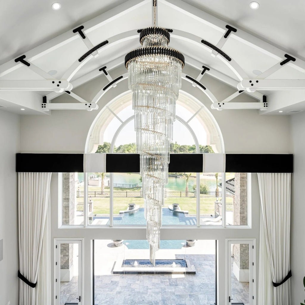 Olivia Crystal Modern Stair Chandelier installed in a bright white foyer entry with arched windows