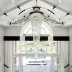 Olivia Crystal Modern Stair Chandelier installed in a bright white foyer entry with arched windows