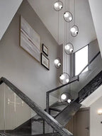 Postmodern Ring Pendant Light for Staircase with gold ring pendants hanging in a curved stairwell