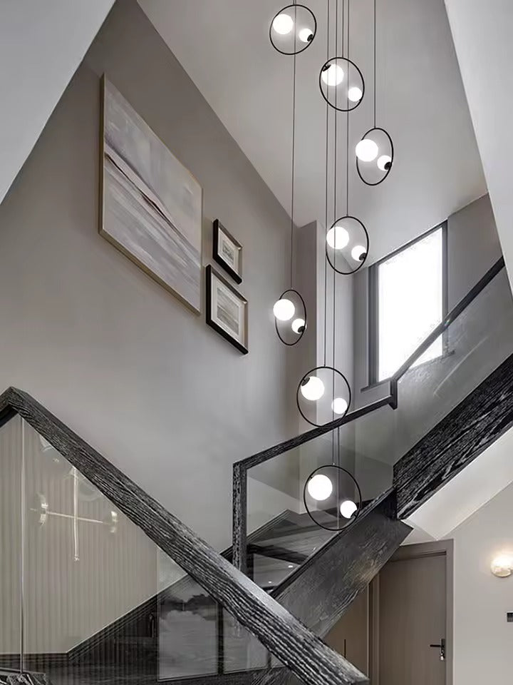 Postmodern Ring Pendant Light for Staircase with gold ring pendants hanging in a curved stairwell
