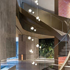 Postmodern Ring Pendant Light for Staircase installed beside a curved stairway with glowing globe lights