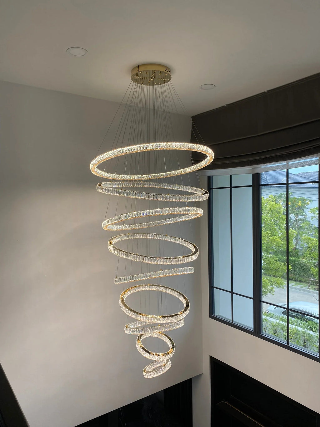 6 Tier Crystal Ring Chandelier for High Ceiling installed in a tall entryway beside balcony windows