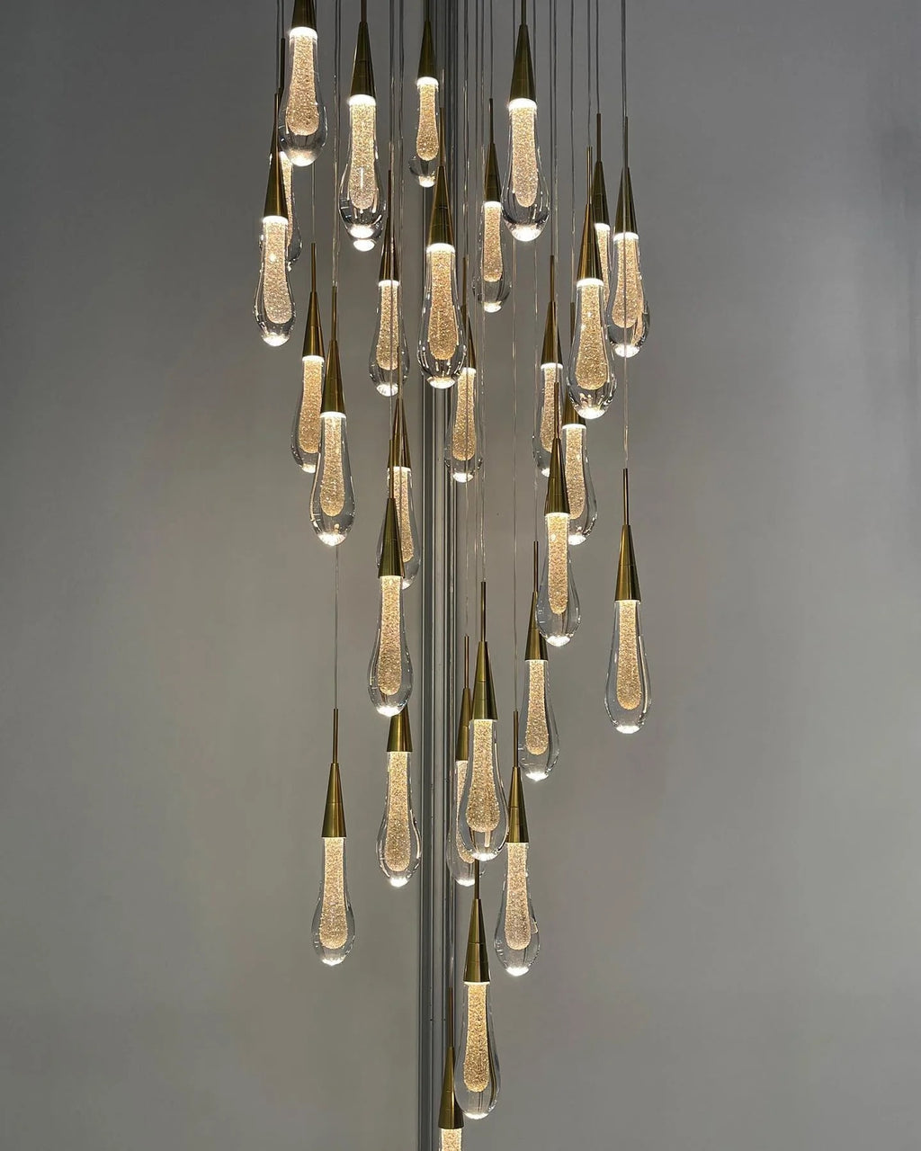 Spiral Raindrop Staircase Ceiling Lighting long crystal chandelier installed in a high ceiling interior