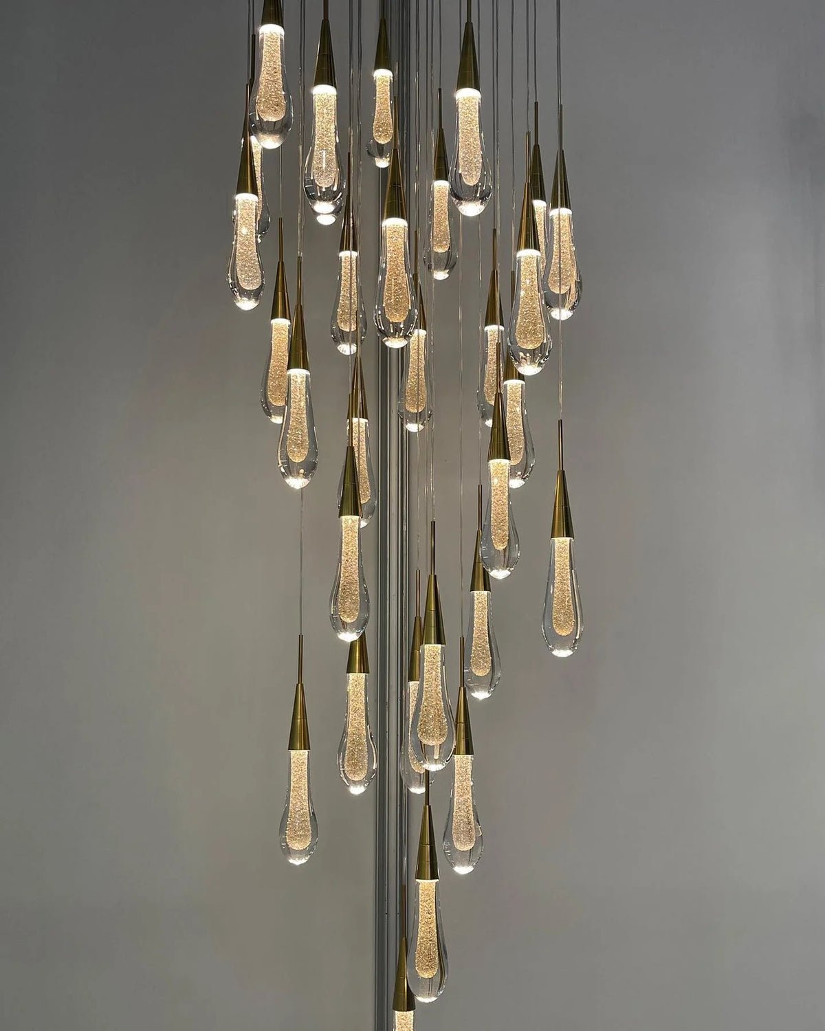 Spiral Raindrop Staircase Ceiling Lighting long crystal chandelier installed in a high ceiling interior