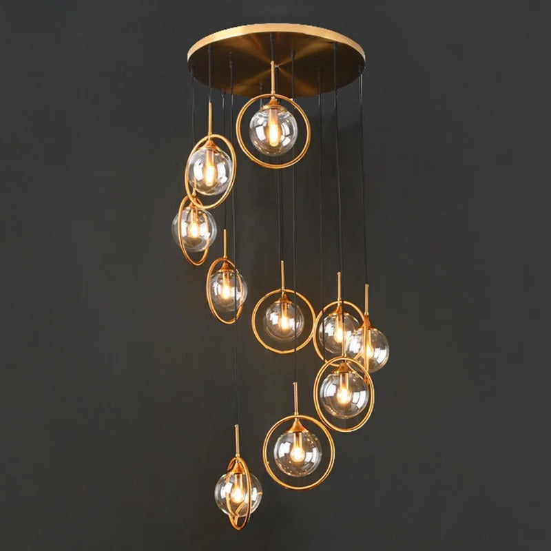 Tenza Modern Staircase Chandelier close view of amber glass spiral ball pendants with gold hardware
