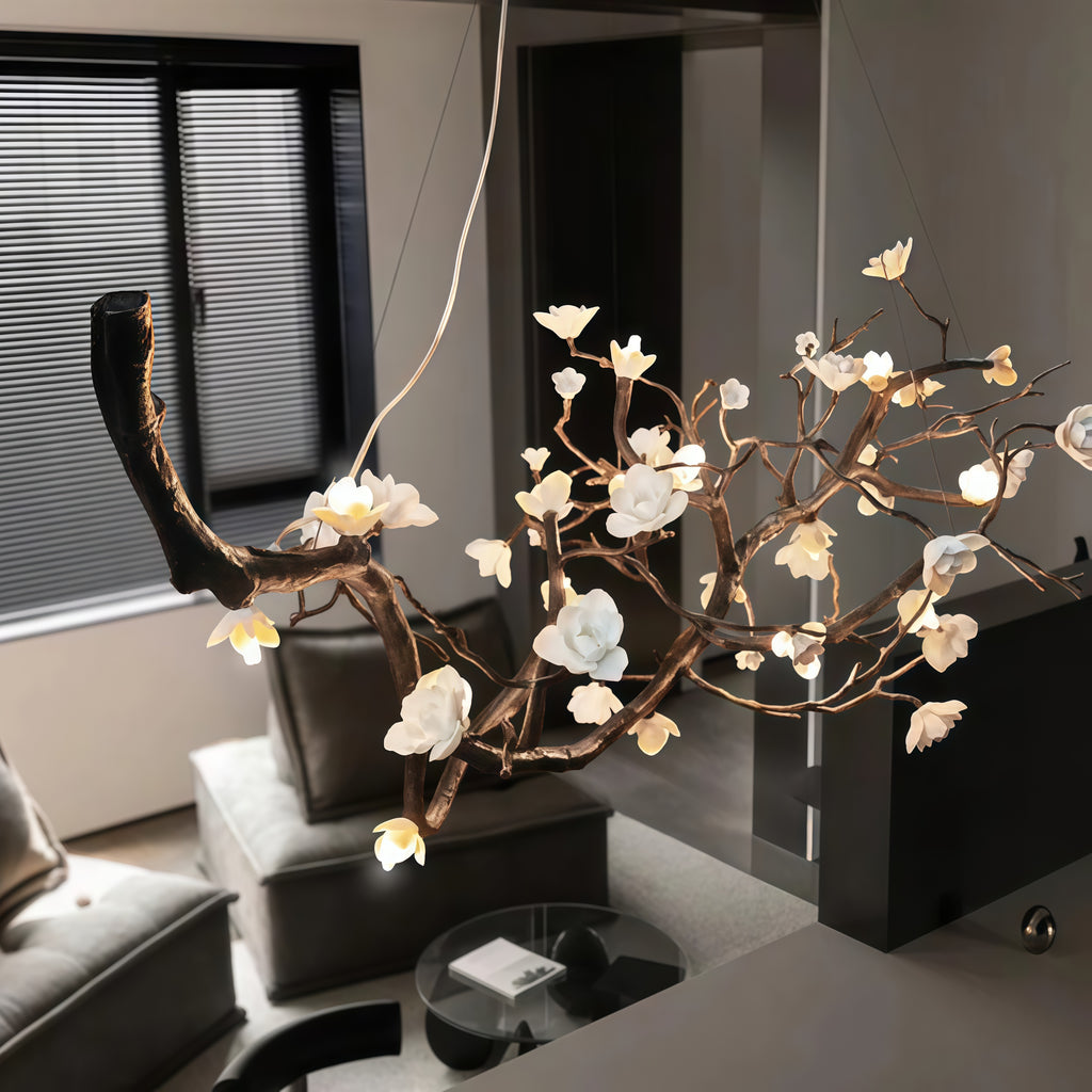 Close-up view of Wanos Ceramic Flower Branch Chandelier showing the handcrafted branch structure, white ceramic flowers, warm LED glow, and delicate suspension wires.