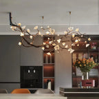 Wanos Crystal Flower Branch Chandelier suspended above a modern kitchen island, featuring sculptural branch details, glowing flower petals, and warm brass ceiling canopies.
