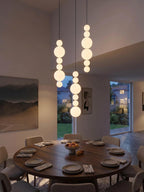 White Multi Globe Pendant Light for Staircase and High Ceiling above a round dining table with opal glass globes